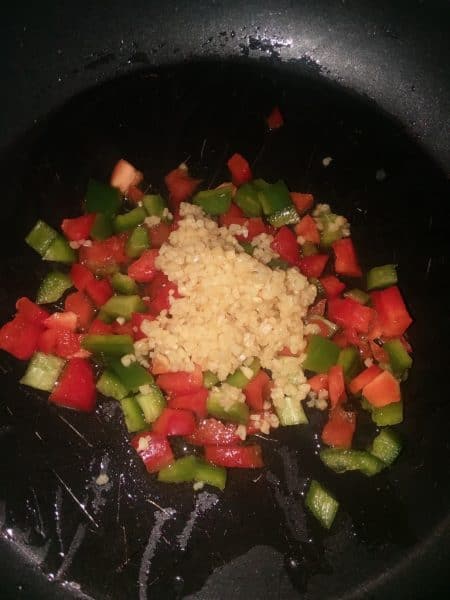 peppers, garlic in frying pan.