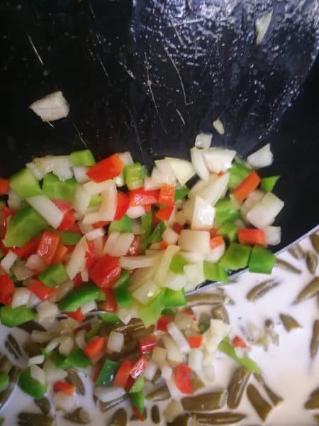 onion and peppers in frying pan