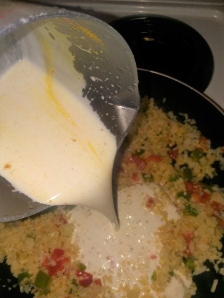 pouring coconut milk into rice