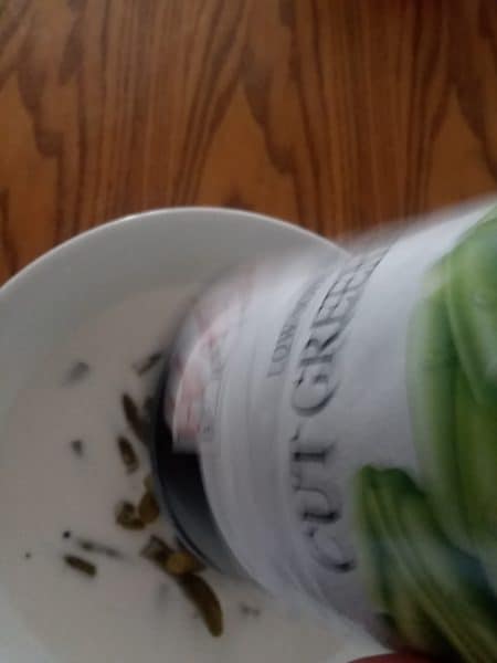 pouring green beans into bowl