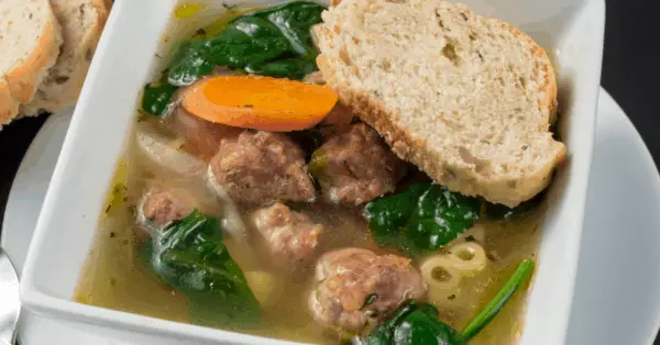 italian wedding soup in a bowl with piece of toast