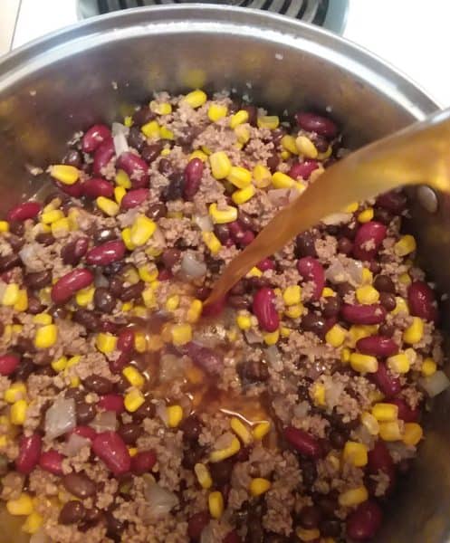 beef stock pouring into pot, taco soup