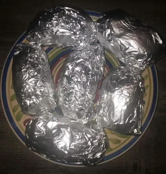 baked potatoes wrapped in tin foil