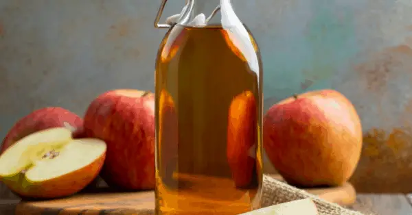 apple cider vinegar in a bottle with apples