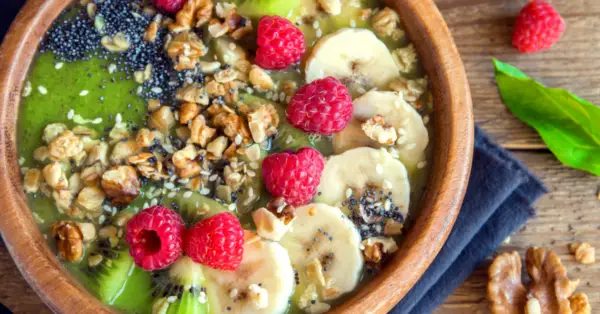 green smoothie with banana, nuts, raspberry toppings