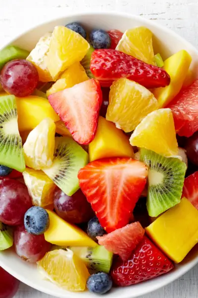 fruit salad with strawberries, pineapples, grapes, blueberries, kiwis, in a bowl