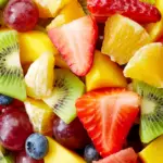 fruit salad with strawberries, pineapples, grapes, blueberries, kiwis, in a bowl