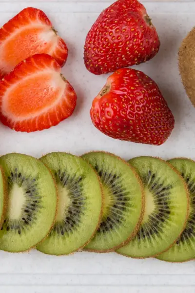 strawberries and kiwis on a cutting board