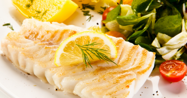 cod on a plate with lemon on top